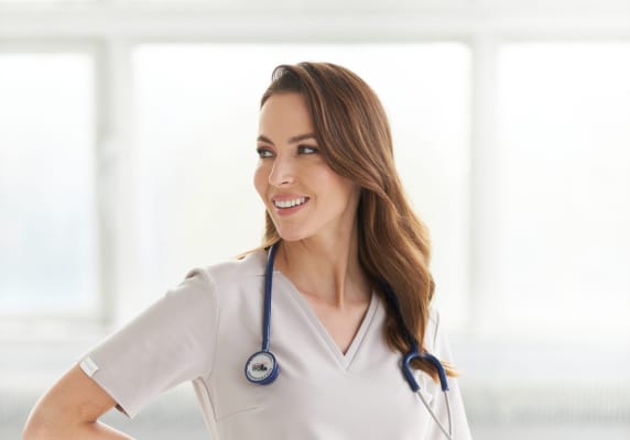Uśmiechnięta kobieta w ubraniu medycznym z stetoskopem