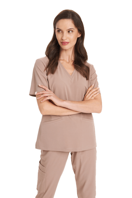 Kobieta w beżowym komplecie odzieży medycznej z krótkim rękawem i kieszeniami.