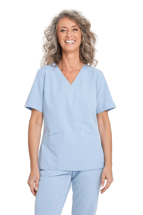 Uśmiechnięta kobieta w jasnoniebieskim komplecie odzieży medycznej.