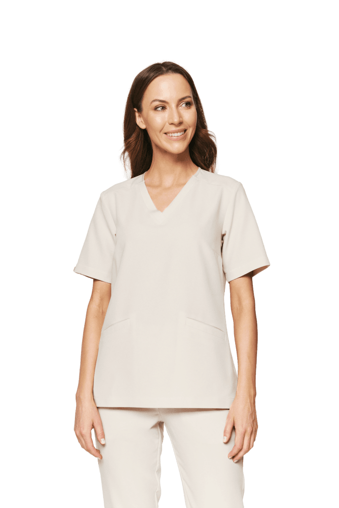 Kobieta w beżowej bluzce medycznej damskiej scrubs Basic COLD NUDE z krótkim rękawem i dekoltem w serek.