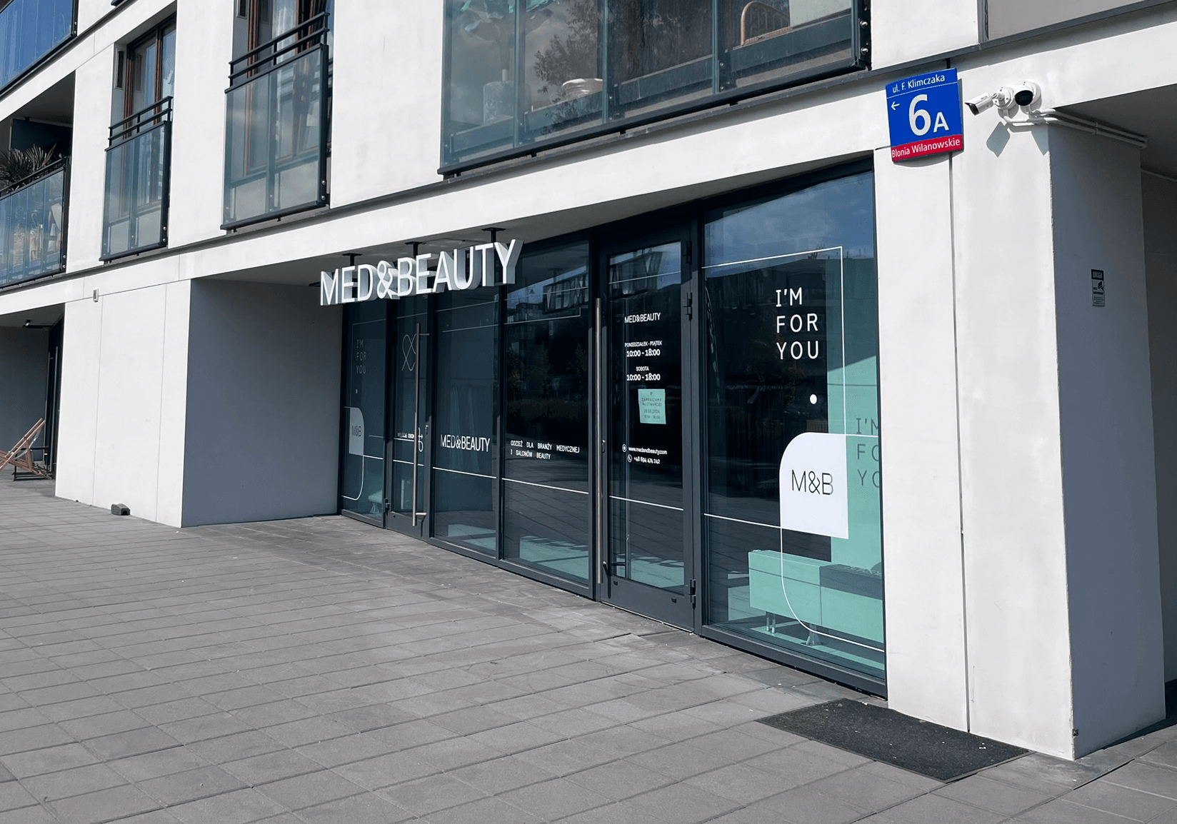 Wejście do sklepu Med&Beauty oferującego odzież medyczną i kosmetyczną.