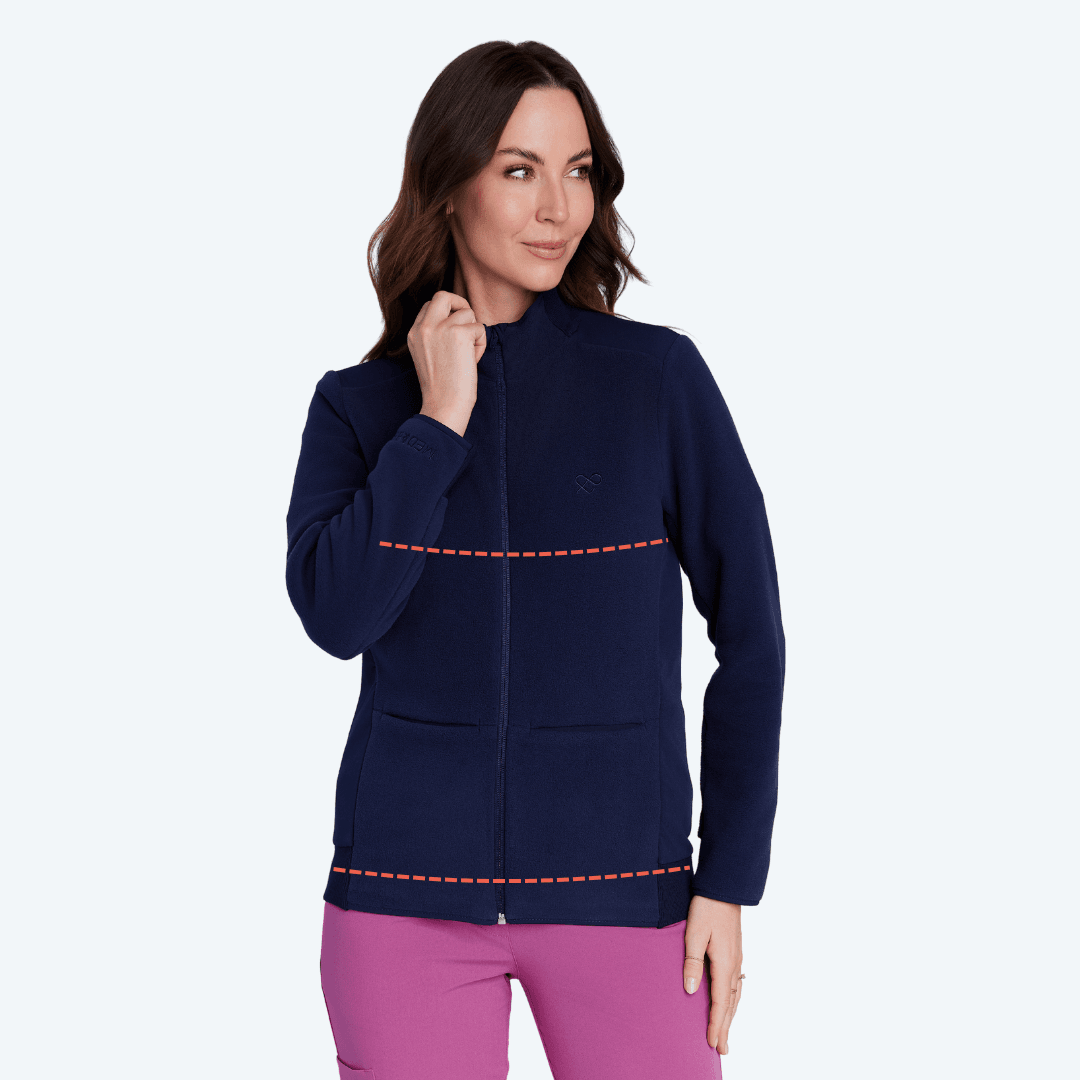 Kobieta w granatowej kurtce medycznej i różowych spodniach, prezentuje wygodną odzież medyczną.