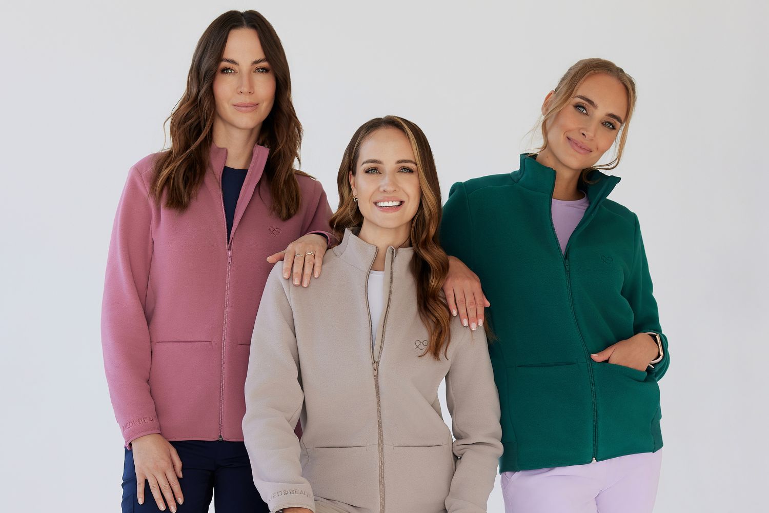Trzy kobiety w kolorowych, ciepłych kurtkach medycznych marki Med&Beauty.