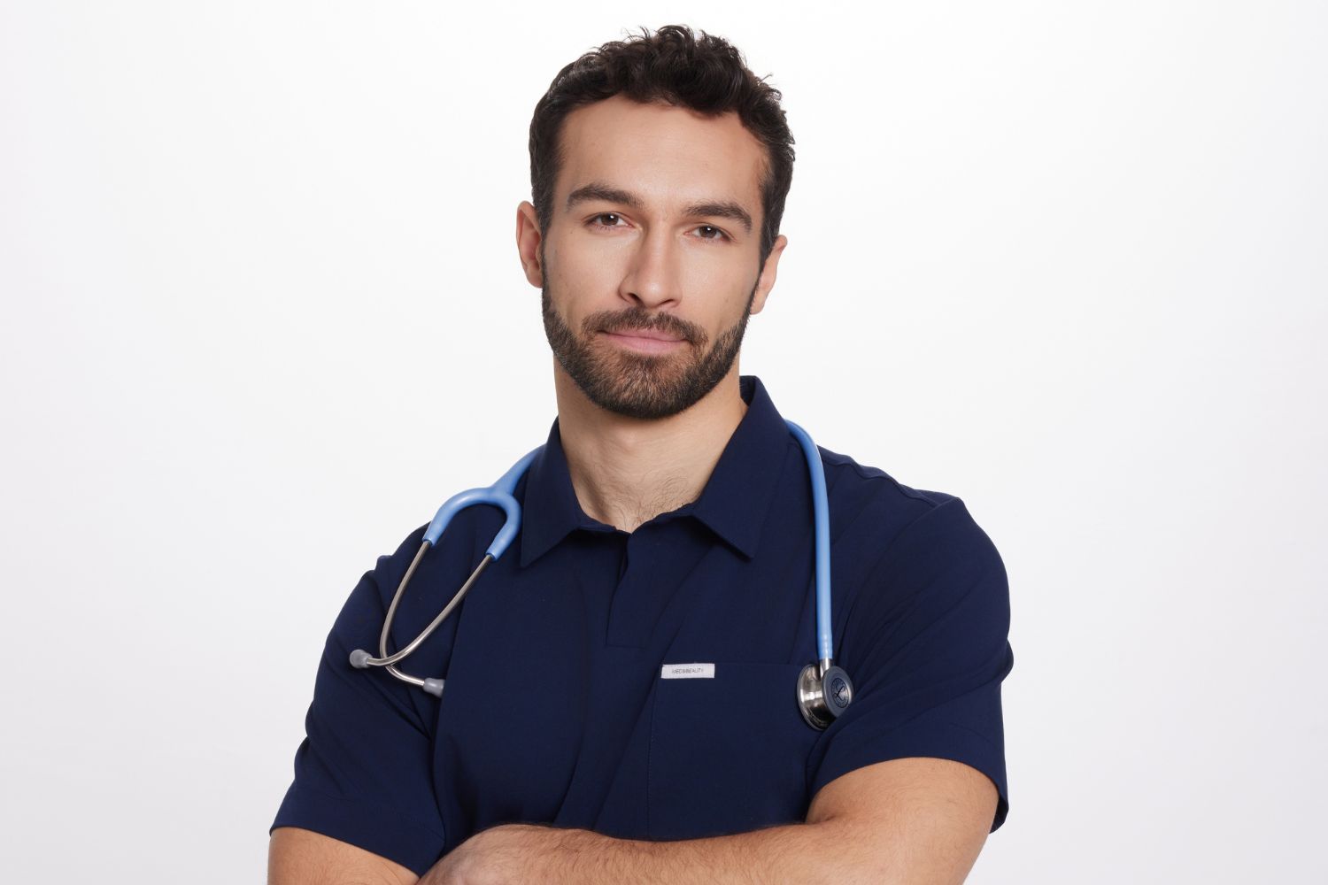 Mężczyzna w granatowym ubraniu medycznym z niebieskim stetoskopem na szyi